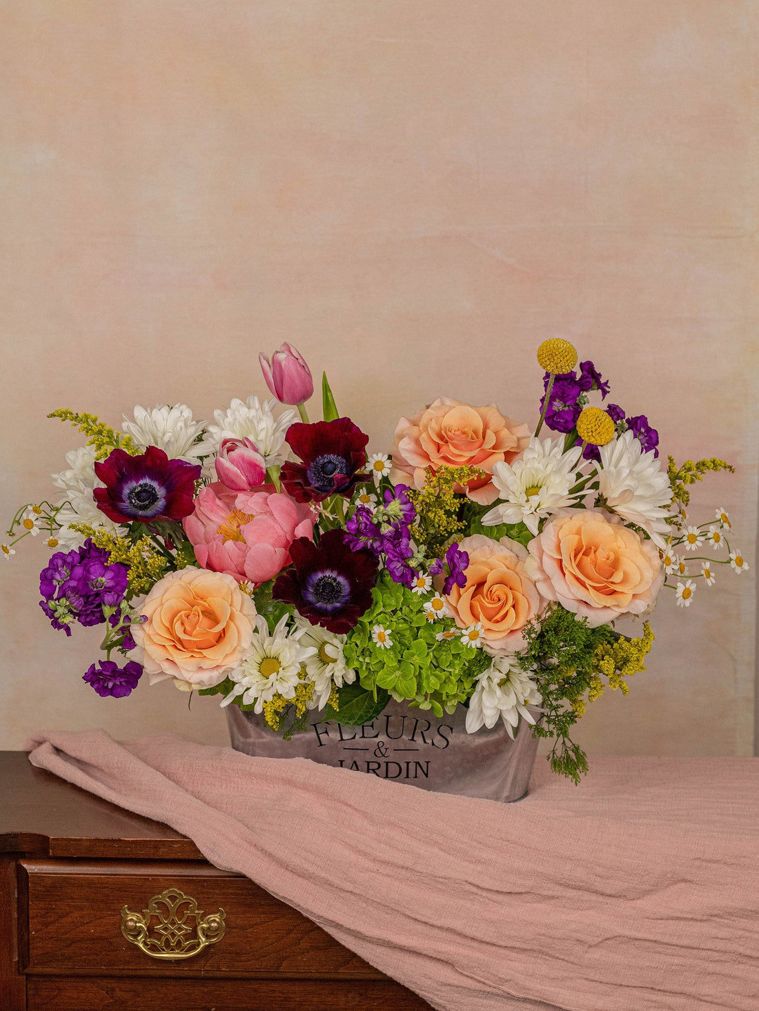 The Jardin arrangement: luxurious roses, peonies, and anemones in peach, coral, and deep purple