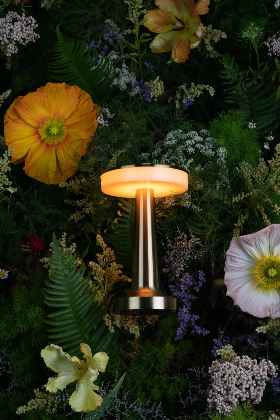 Brass lamp nestled in a floral wall for a brand activation, by Adore Flowers, Los Angeles