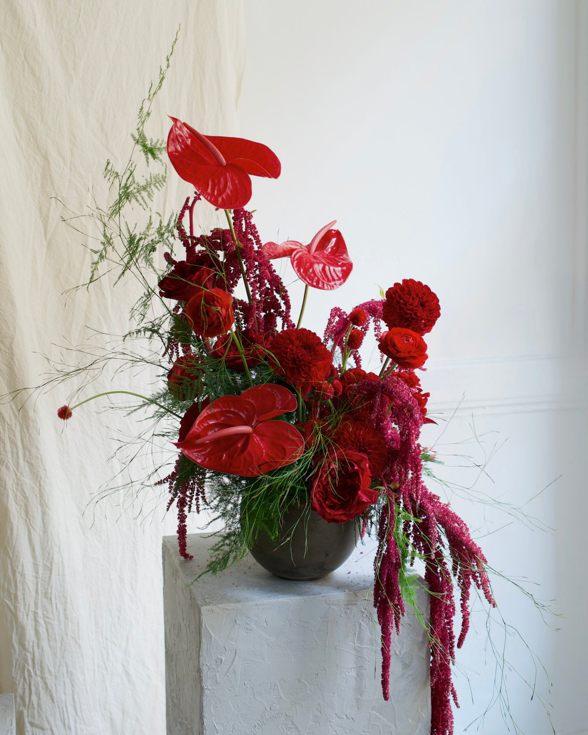 Custom designer arrangement, florist's choice with red anthurium, red dahlias, garden roses and trailing amaranthus in a black ceramic vase, Adore Flowers Los Angeles
