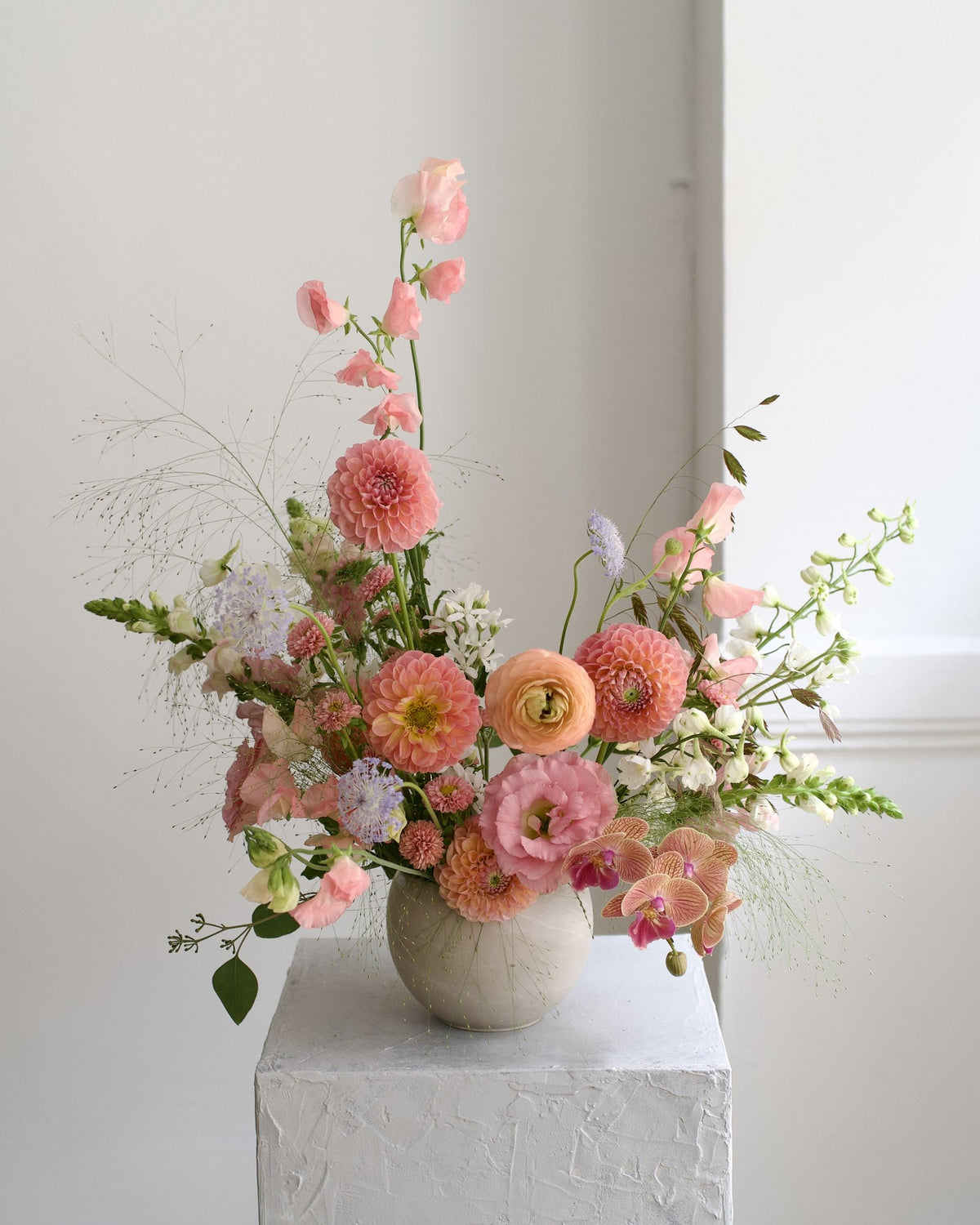 Delicate Blushes vase arrangement variation, coral dahlias, peach ranunculus, sweet peas and phalaenopsis orchid in a stone vase, Adore Flowers Los Angeles