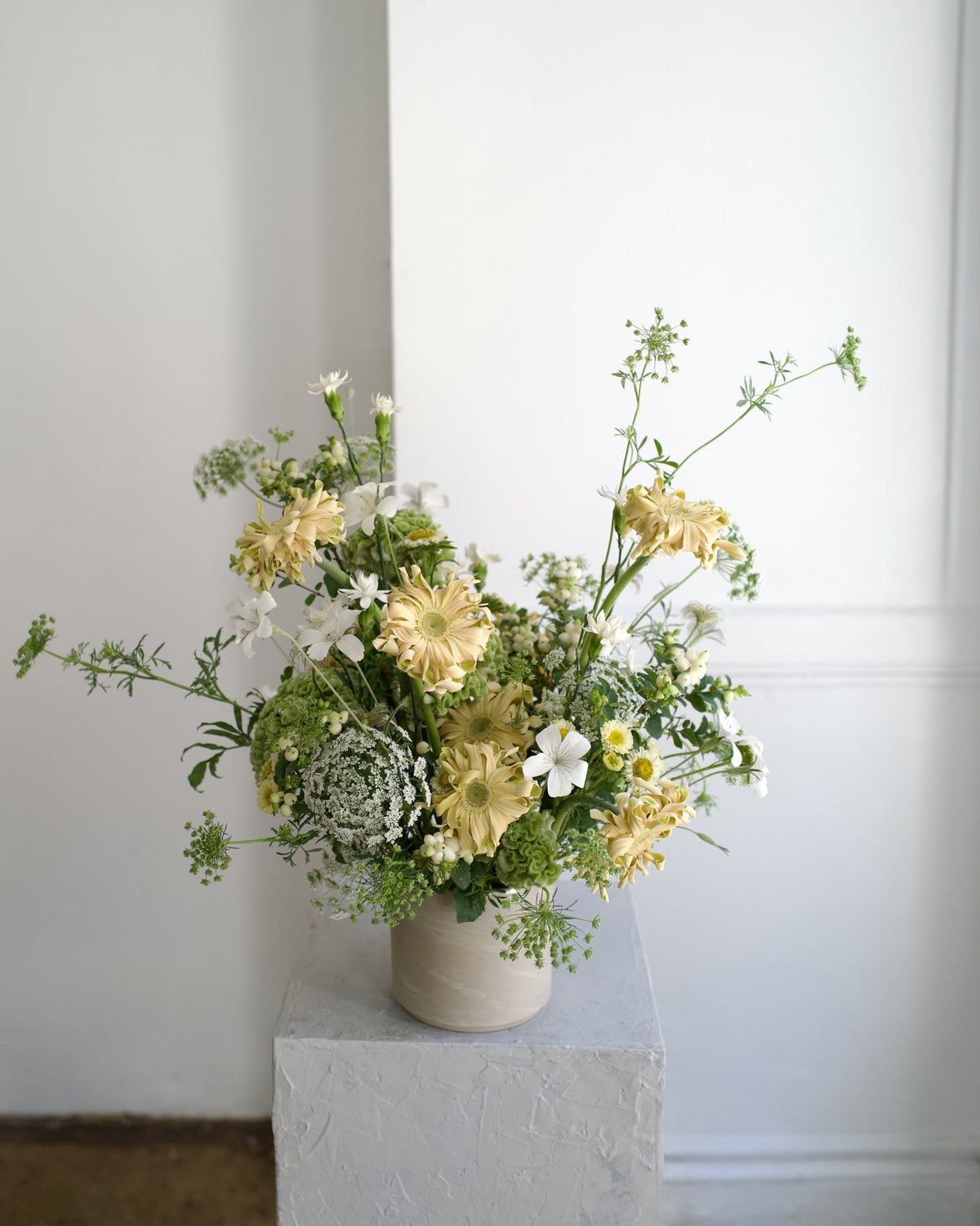 Earthy Neutrals vase arrangement variation, pale yellow gerberas, Queen Anne's lace, white nicotiana and green textures in a stone vase, Adore Flowers Los Angeles