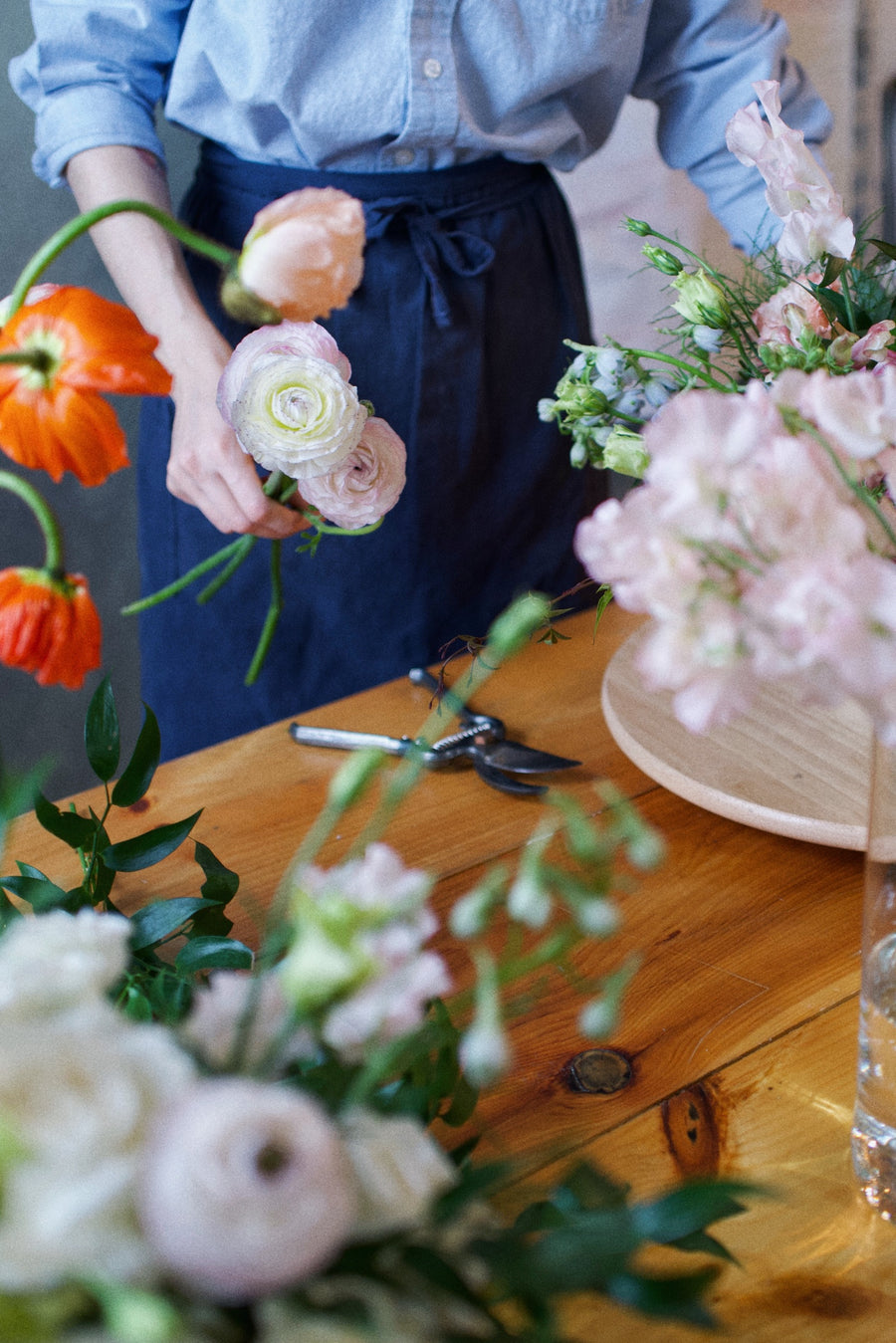 Florist arranging ranunculus and garden flowers in the Adore Flowers studio, Los Angeles