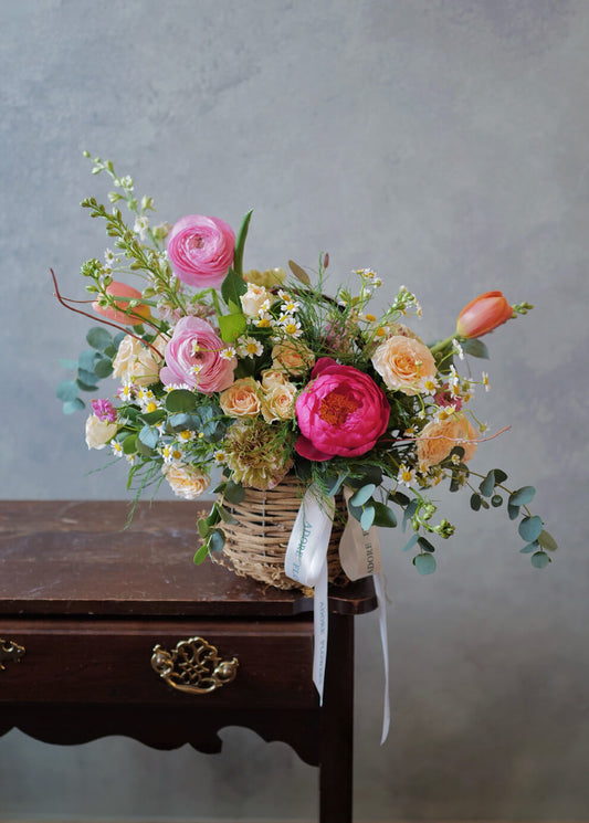 Wide view of Spring Peony & Ranunculus basket arrangement with eucalyptus and chamomile—same-day delivery Philadelphia