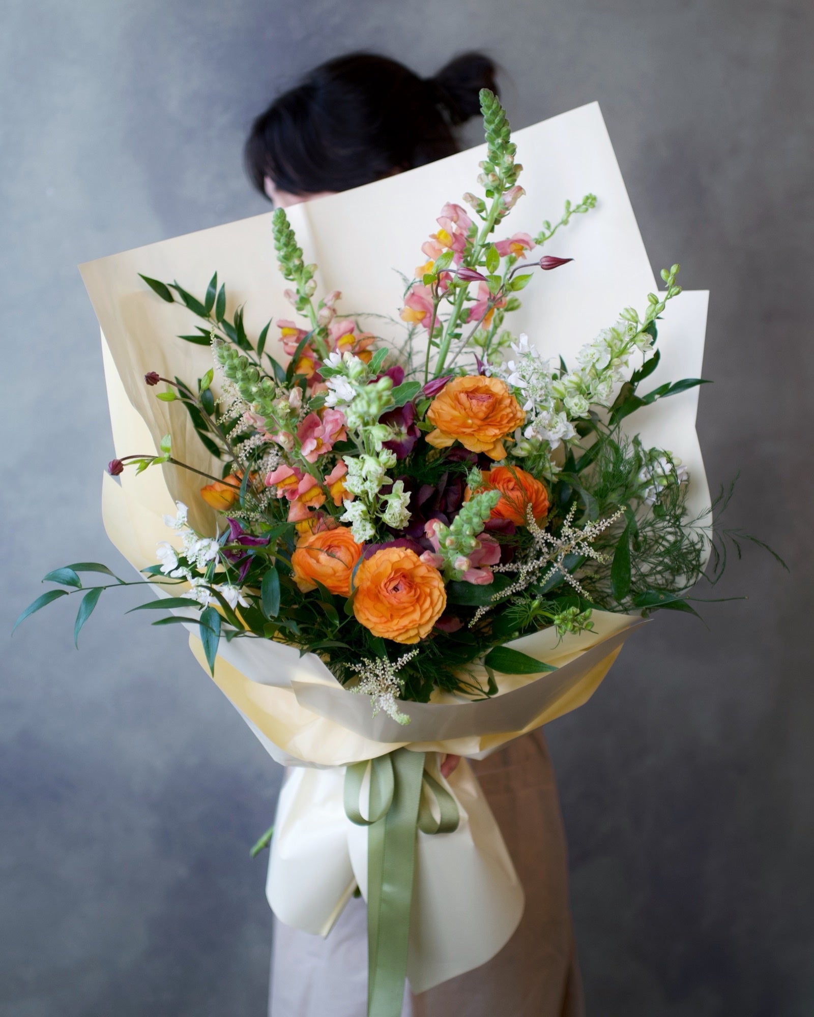 The Wild Bunch bouquet, orange ranunculus and snapdragon with wild greenery hand-tied in wrap, Adore Flowers Los Angeles