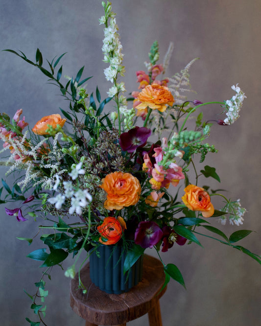 The Wild Bunch arrangement in a stone vase, orange wildflower garden flowers, same-day delivery Los Angeles