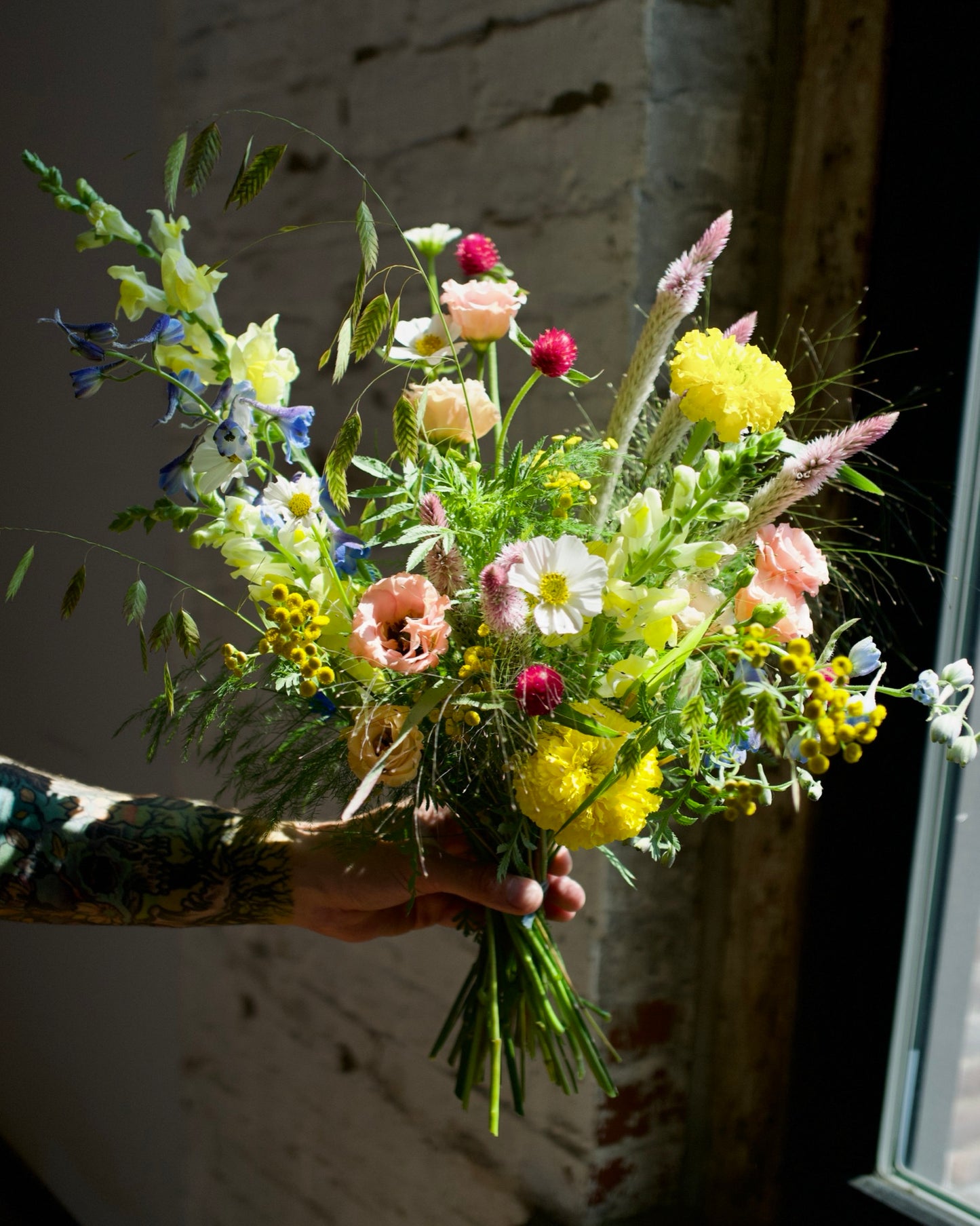 Wildflower bouquet hand-tied with yellow marigolds, snapdragons, blue delphinium and wild grasses, The Wild Bunch by Adore Flowers Los Angeles